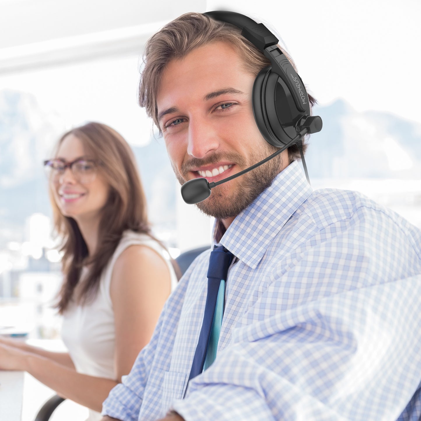 Businessman in an office wearing his Deluxe MM Headset with Boom Microphone and speaking to a colleague..