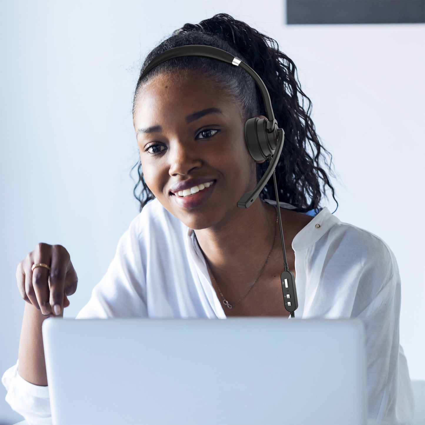 Picture of a Businesswoman in an office wearing her Connect USB Mono Headset with Boom Microphone and speaking to a customer.