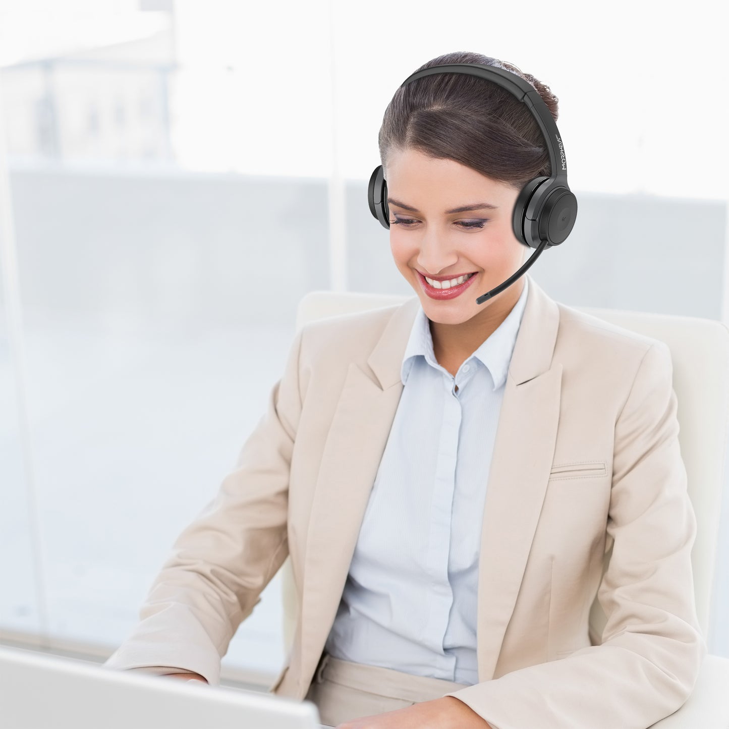 Business woman in an office wearing her Advantage Stereo Wireless Headset with Boom Microphone and speaking to a customer.