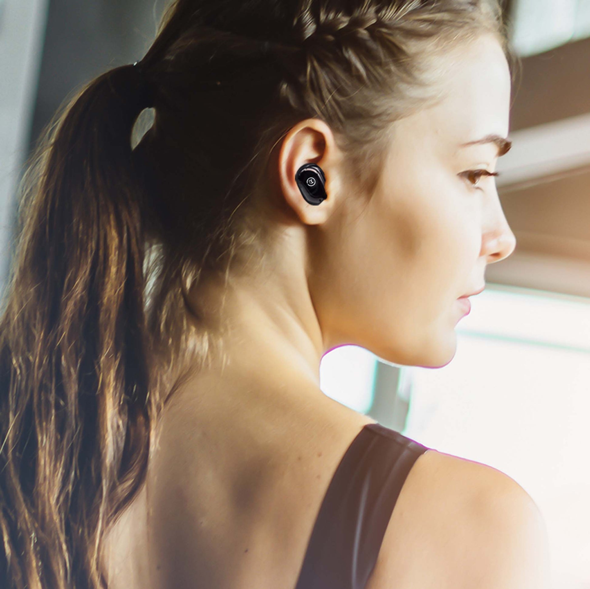 Photo of Morpheus 360 Spire True Wireless Earbuds, a white female wearing the Spire True Wireless Earbuds while working out they are Ultra-Light Weight, Touch Control, Sweatproof. 