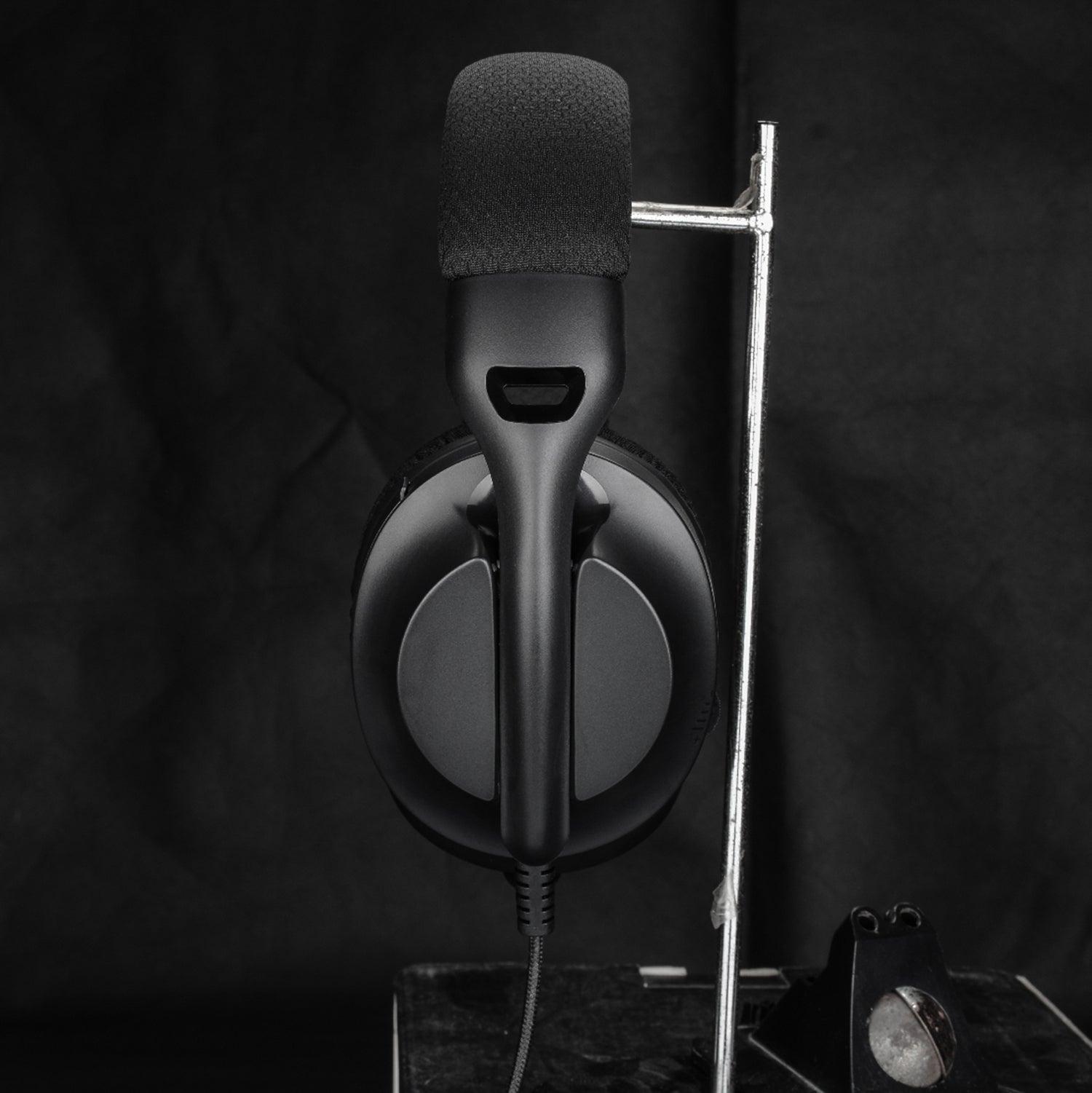 M360 Tri-Mode Gaming Headset In Black with Microphone Down Tilted On Headset Stand Side View