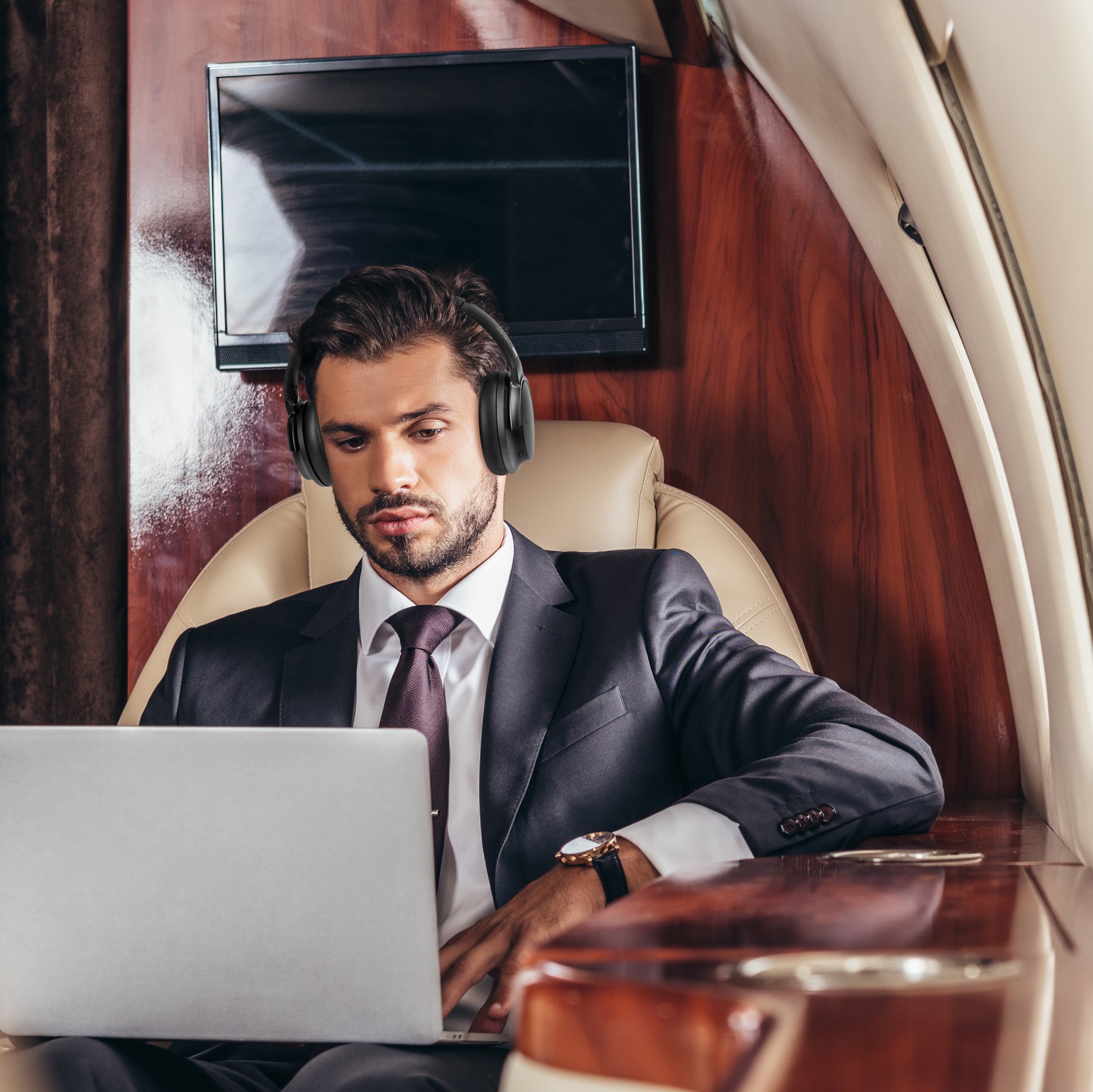 Photo of Morpheus 360 Krave HD Wireless Headphones of a white business man using the Krave HD Wireless Headphones working on his computer while on a business trip.
