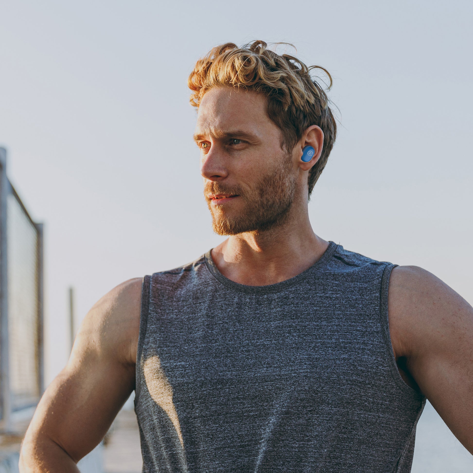 Photo of Morpheus 360 Spire True Wireless Earbuds shows a young athletic white man wearing Spire True Wireless earbuds while working out.