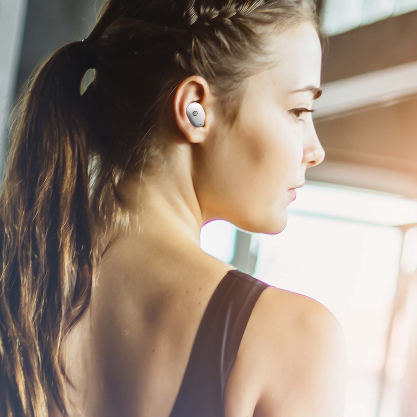 Photo of Morpheus 360 Spire True Wireless Earbuds, a white female wearing the Spire True Wireless Earbuds while working out they are Ultra-Light Weight, Touch Control, Sweatproof. 