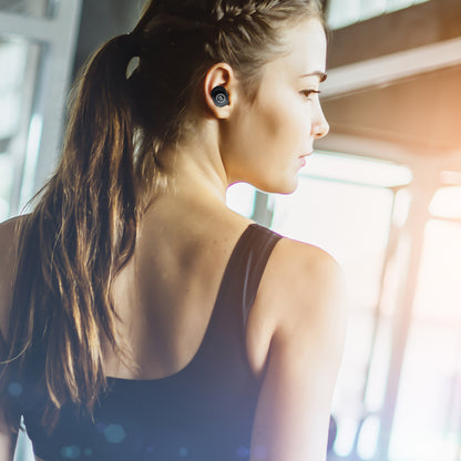 Photo of Morpheus 360 Pulse 360 True Wireless Earbuds shows a sideview of a young white female using the Pulse 360 earbuds while working out.